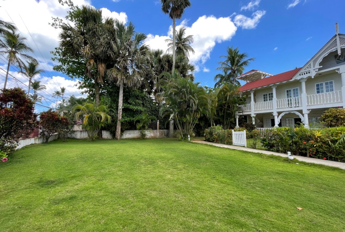 Casa tropical con jardín amplio y palmeras