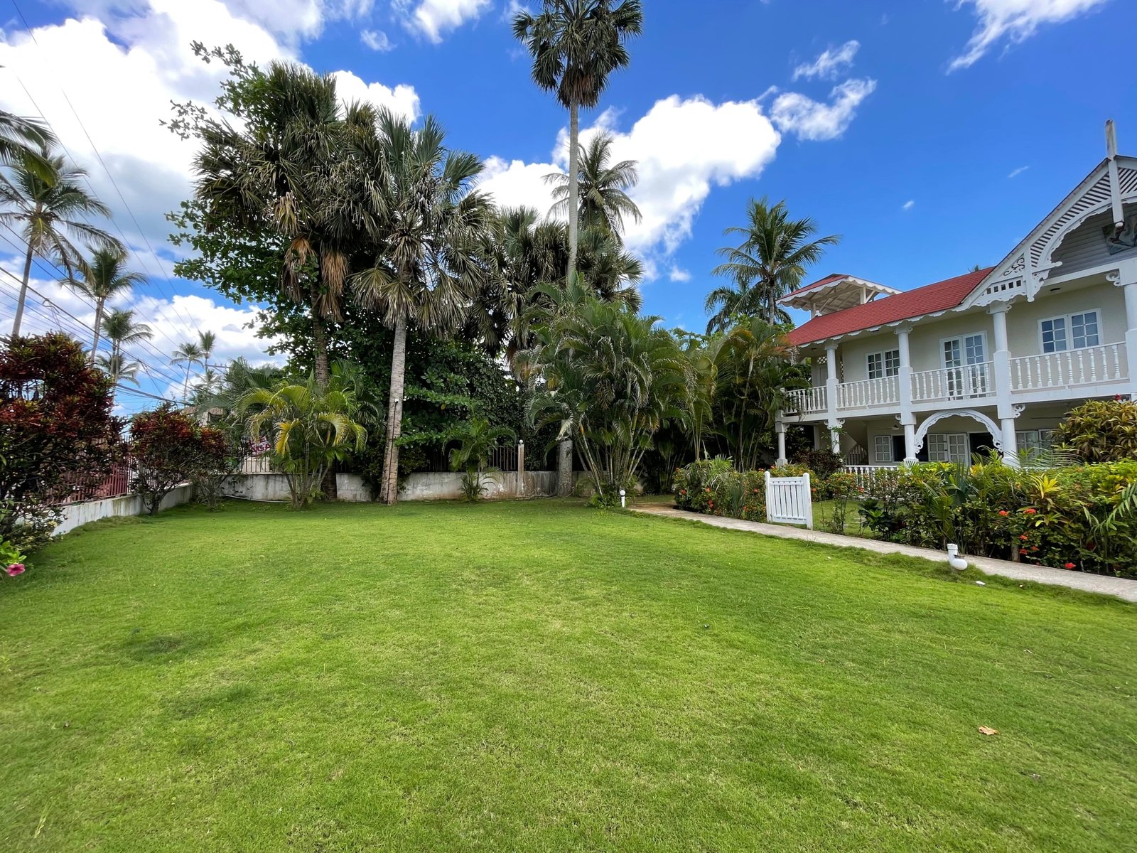Casa tropical con jardín amplio y palmeras