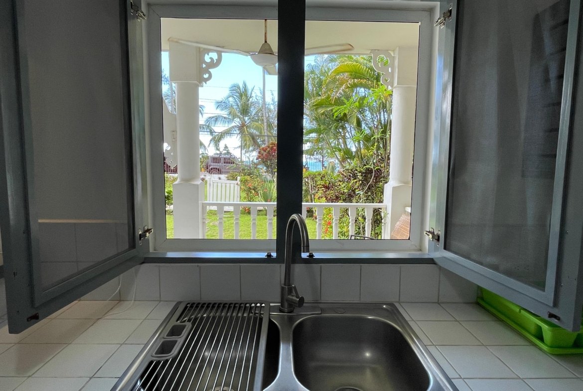 Ventana de cocina con vistas tropicales al mar