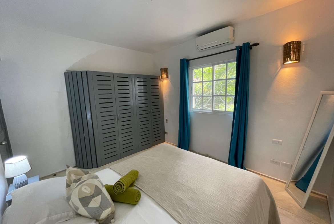 Dormitorio moderno con armario gris y cortinas azules