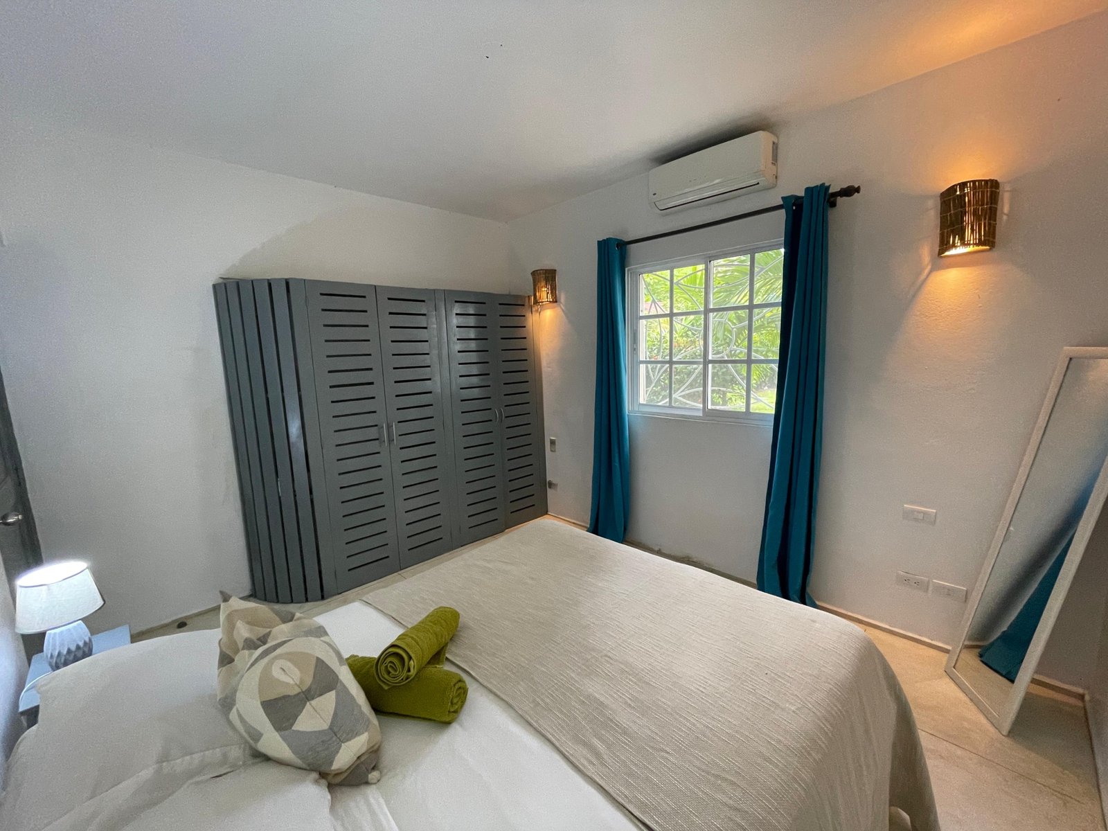 Dormitorio moderno con armario gris y cortinas azules