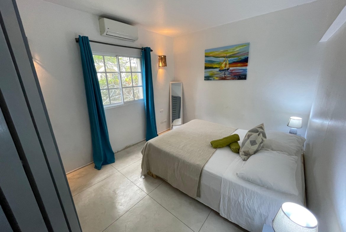 Dormitorio luminoso con cama doble y cortinas azules