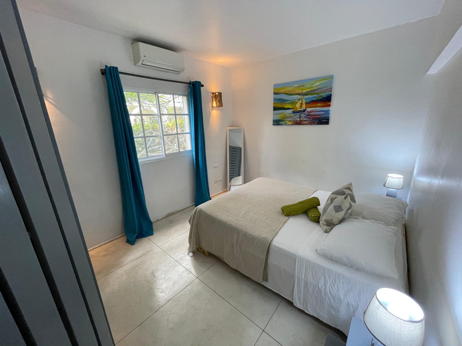 Dormitorio luminoso con cama doble y cortinas azules