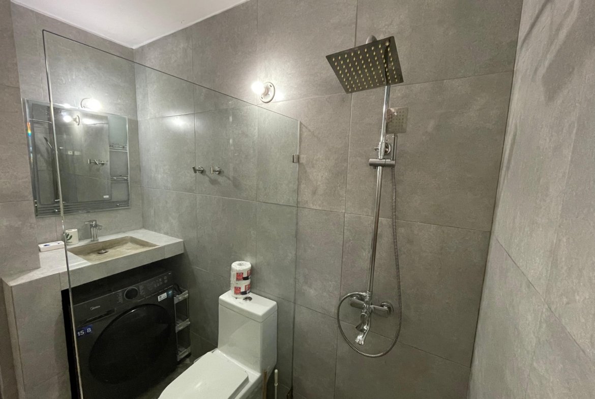 Baño moderno con ducha, lavabo y lavadora