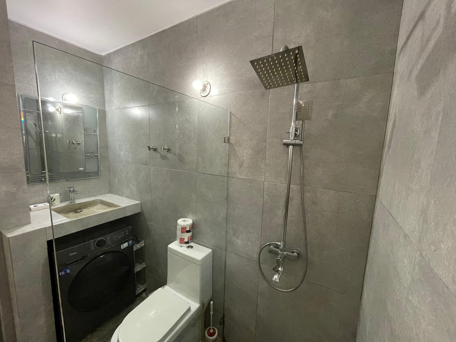 Baño moderno con ducha, lavabo y lavadora
