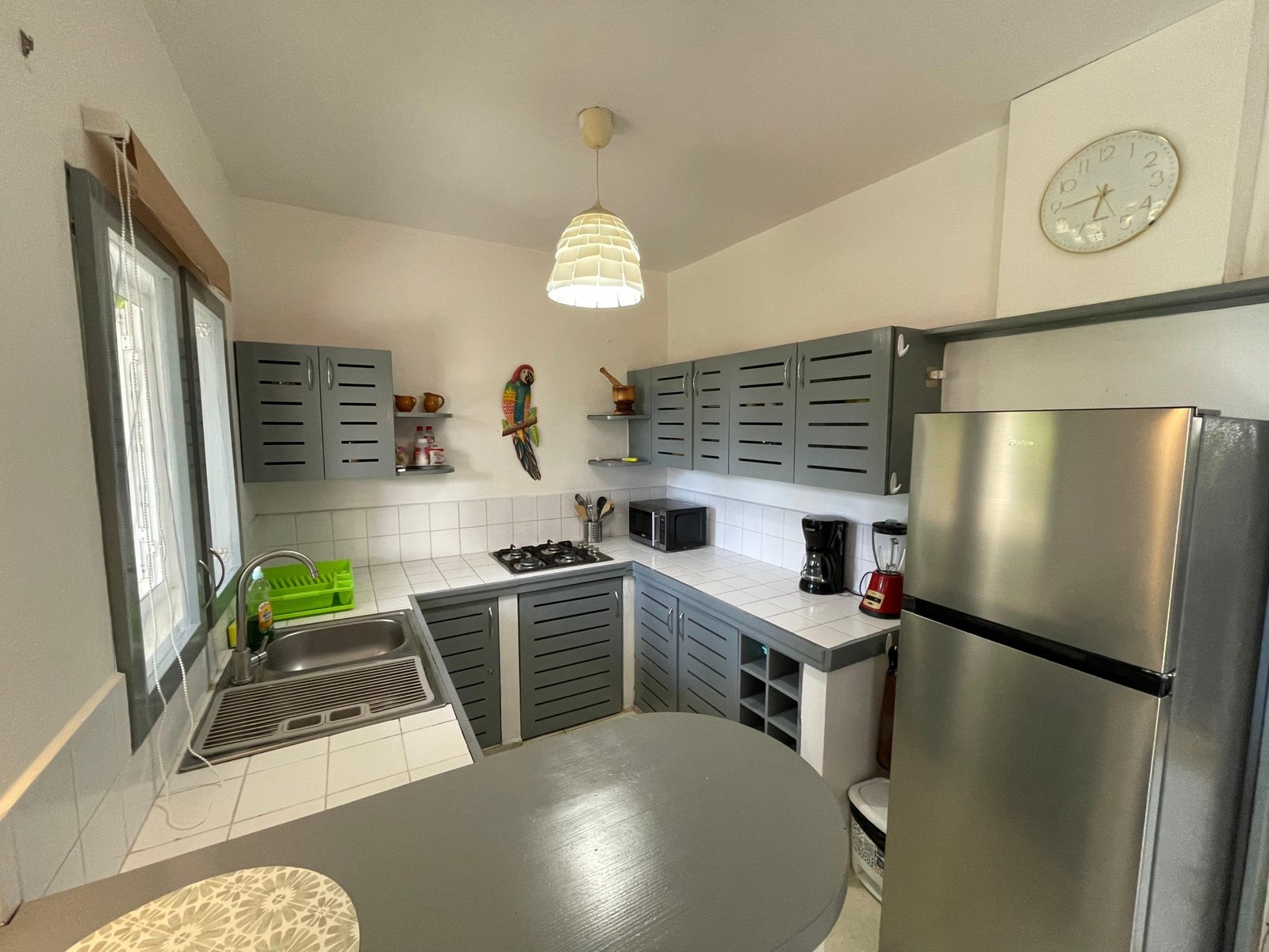 Cocina moderna gris con electrodomésticos y luz natural