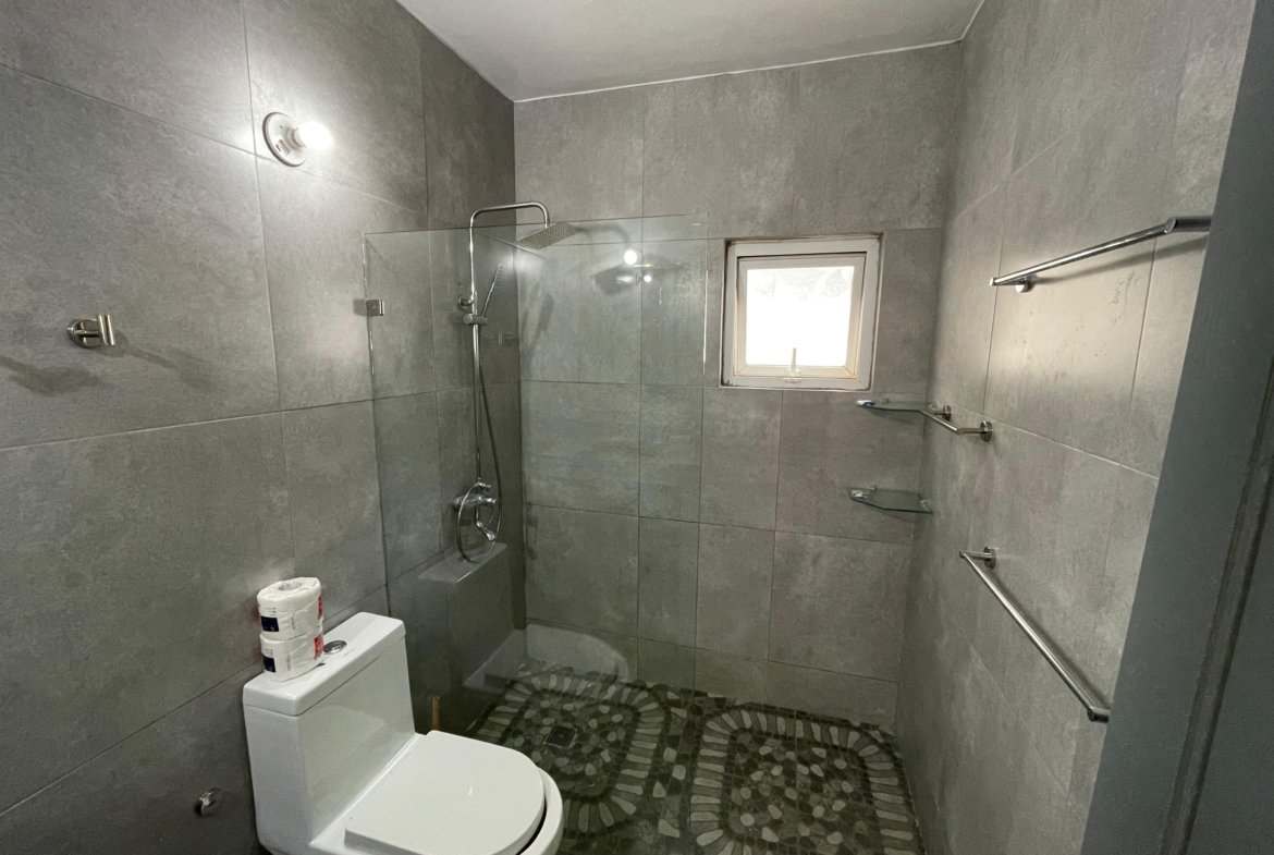 Baño moderno gris con ducha y ventana