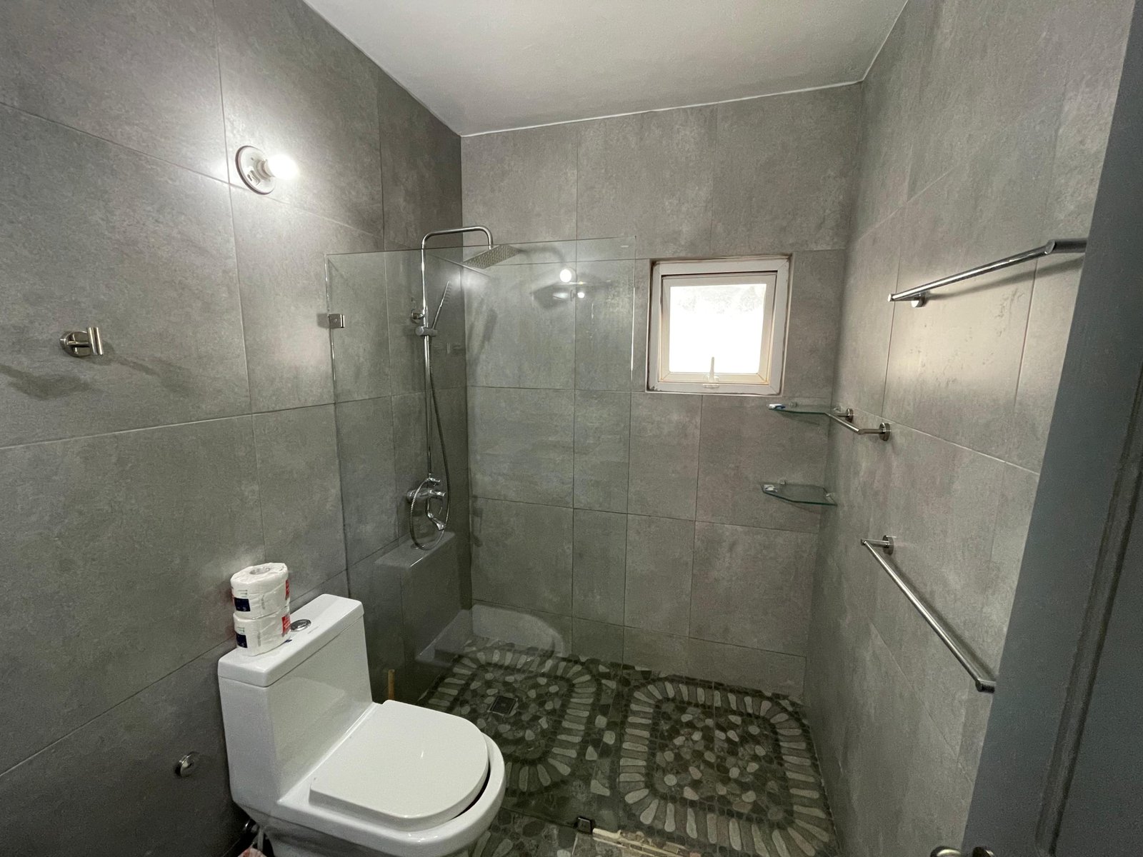 Baño moderno gris con ducha y ventana