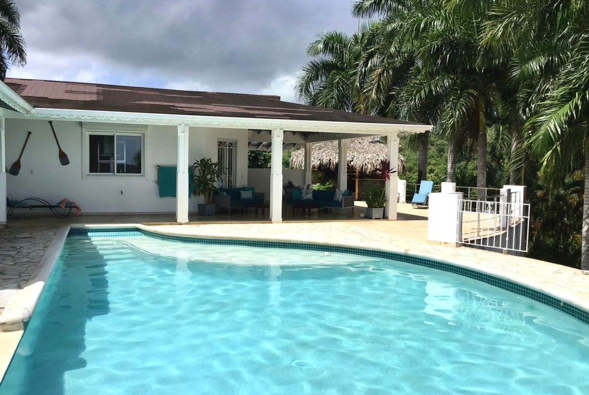 Casa tropical con piscina y palmeras