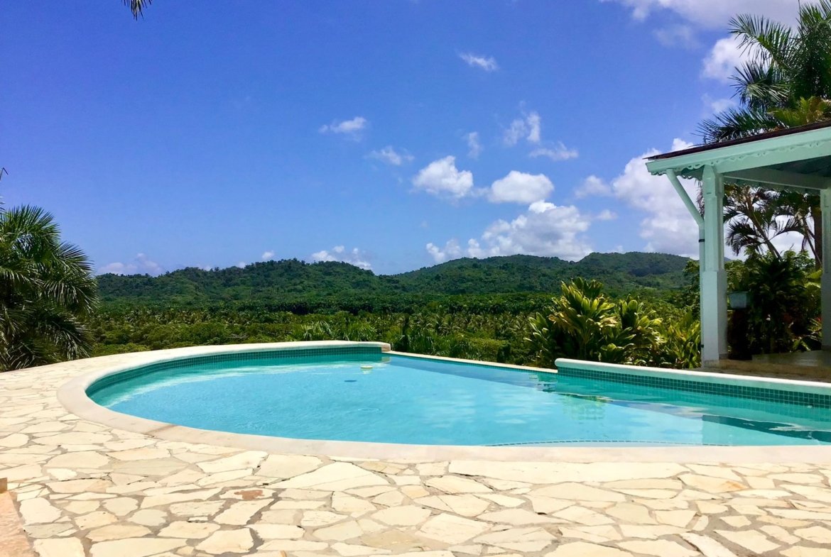 Piscina infinita con vistas a montañas tropicales