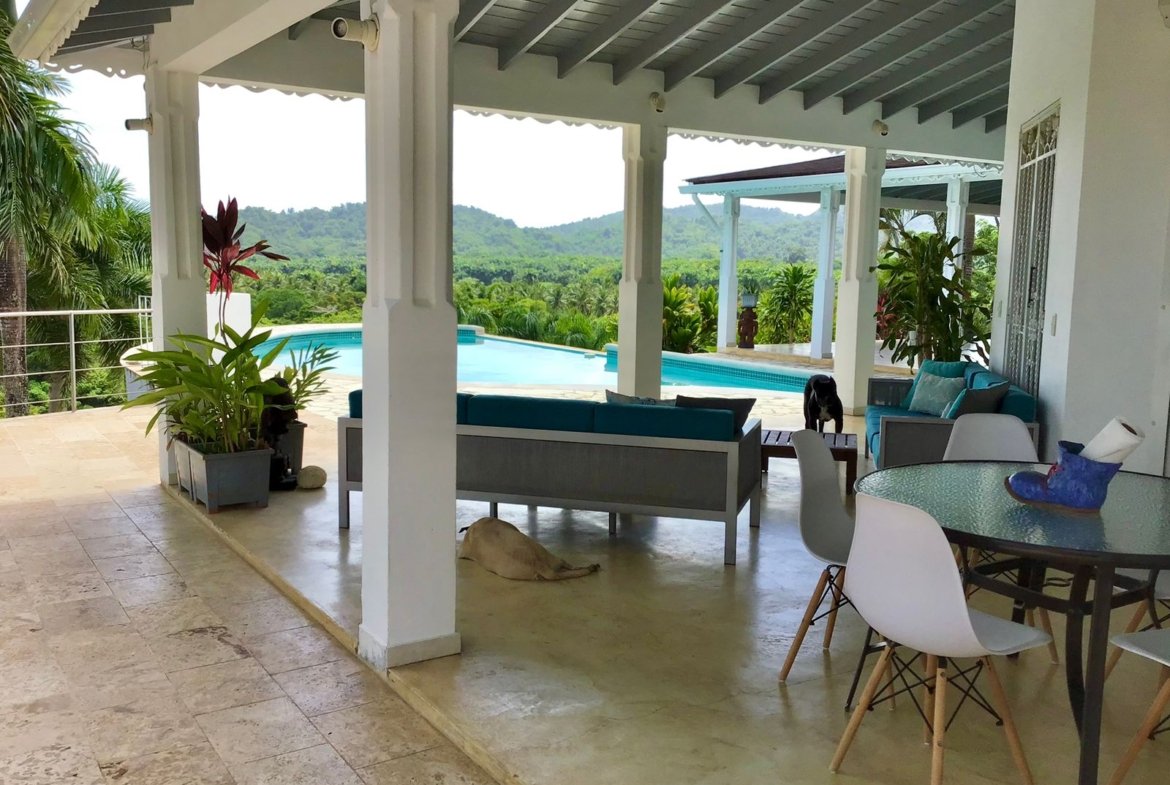 Terraza cubierta con piscina y vistas tropicales