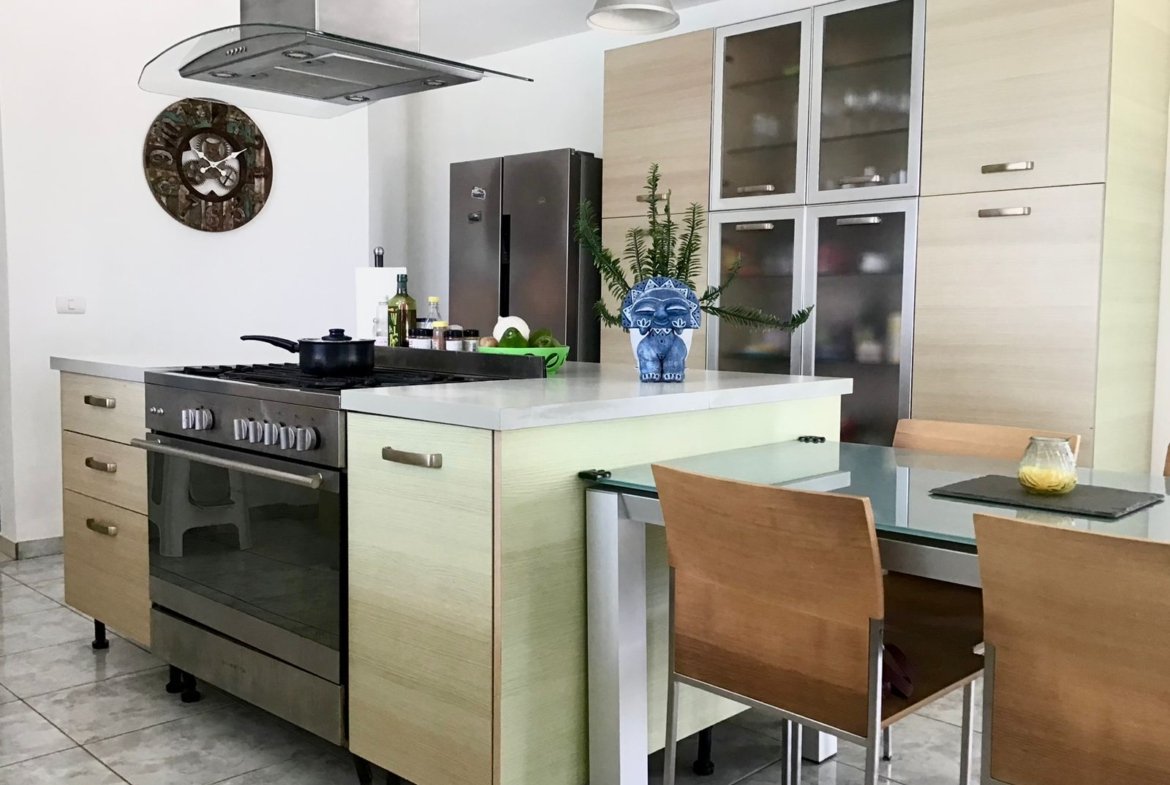Cocina moderna con isla, horno y mesa comedor