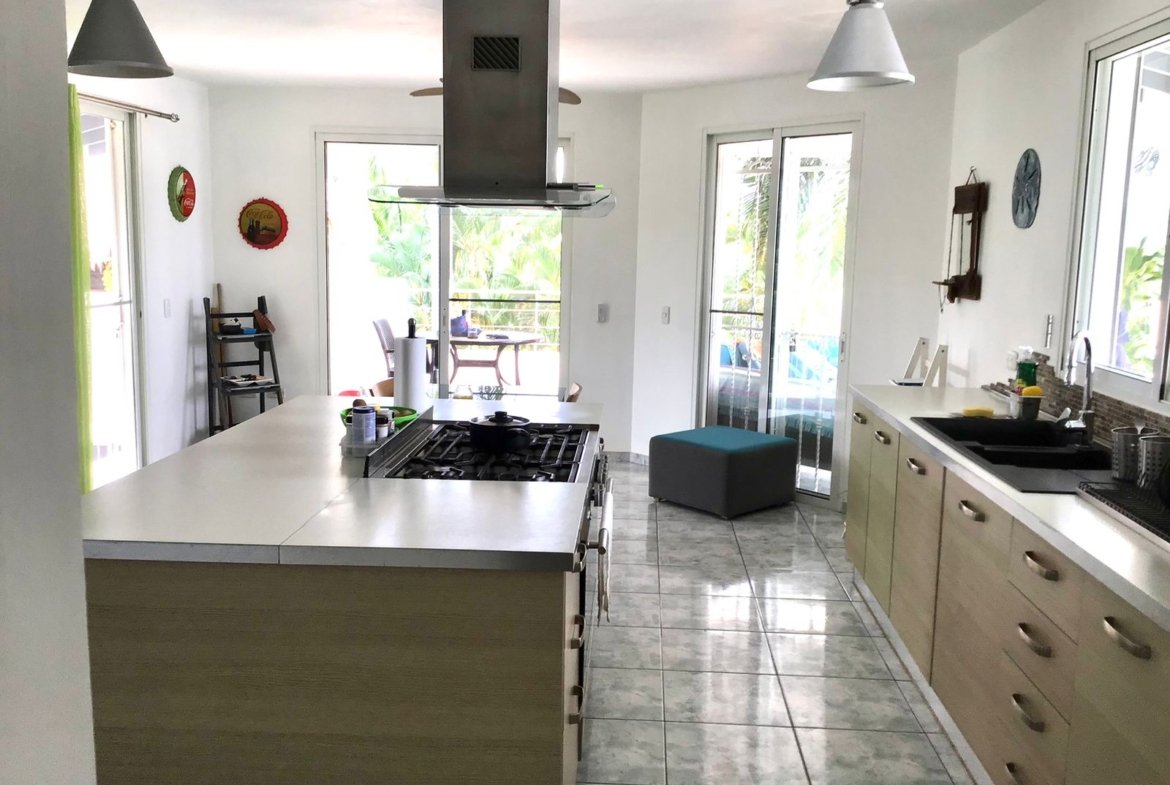 Cocina moderna luminosa con isla y terraza