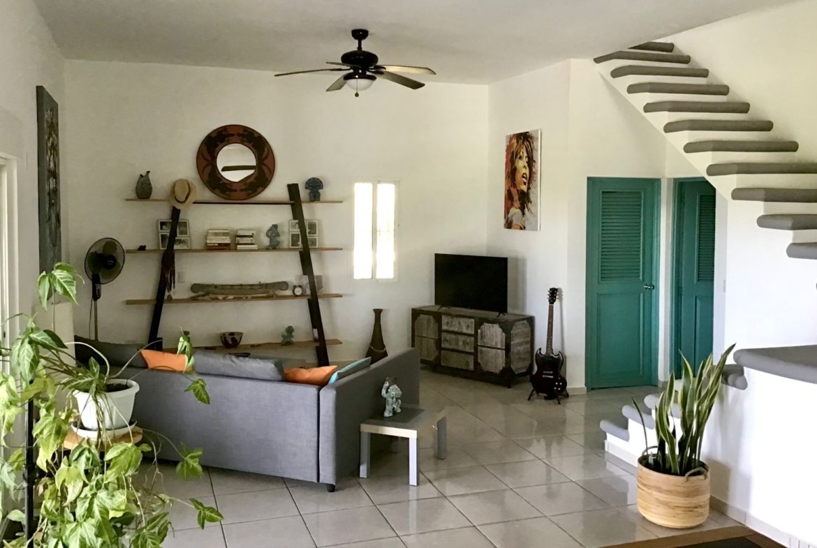 Salón moderno con escalera flotante y plantas