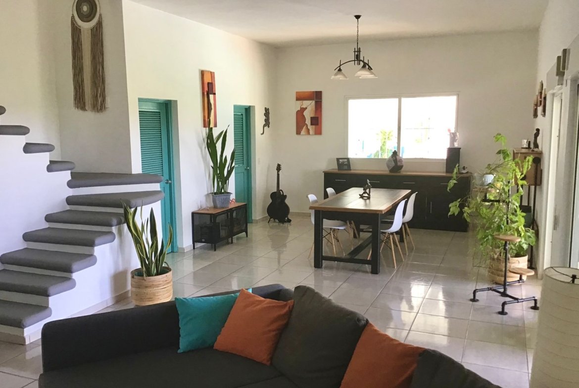 Salón comedor moderno con escalera y plantas