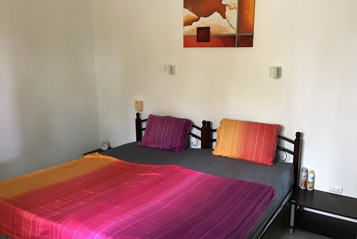 Dormitorio con cama doble y cuadro abstracto