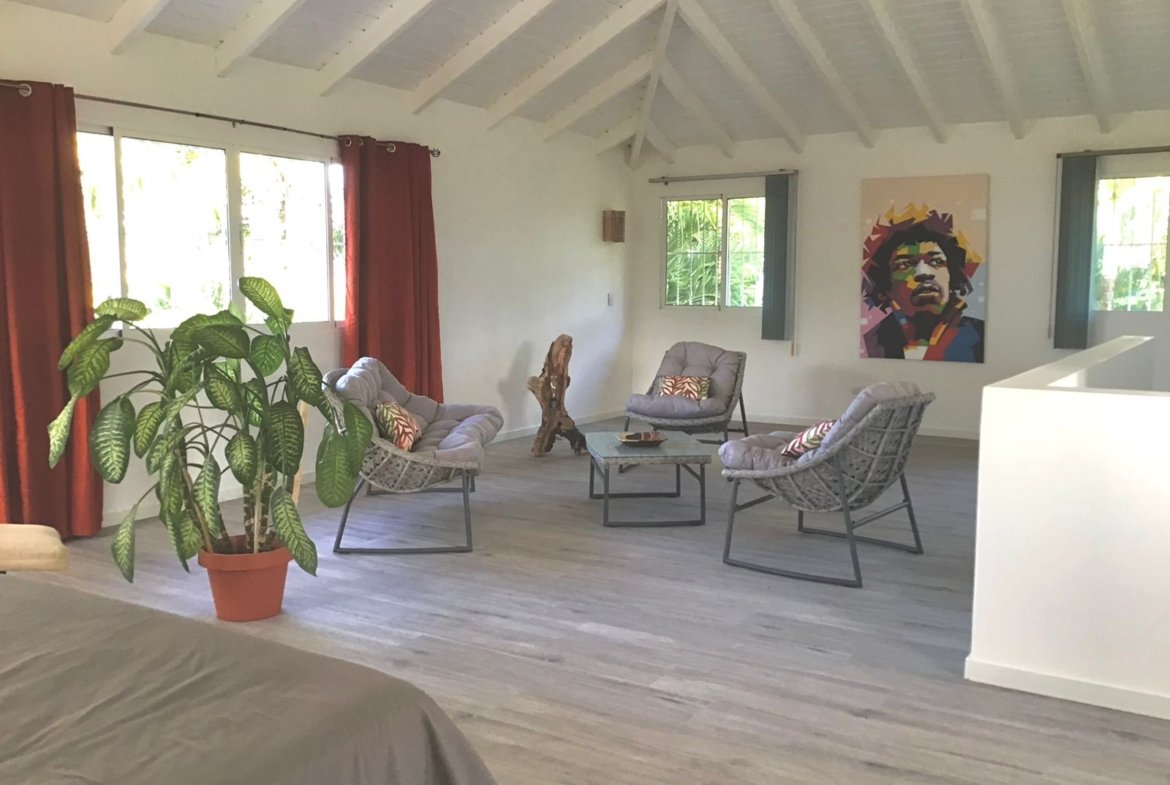 Salón luminoso con sillones y techo alto blanco