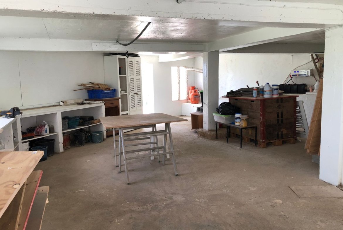 Taller en sótano con mesas y herramientas