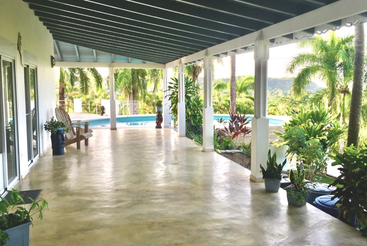 Terraza cubierta con piscina y jardín tropical