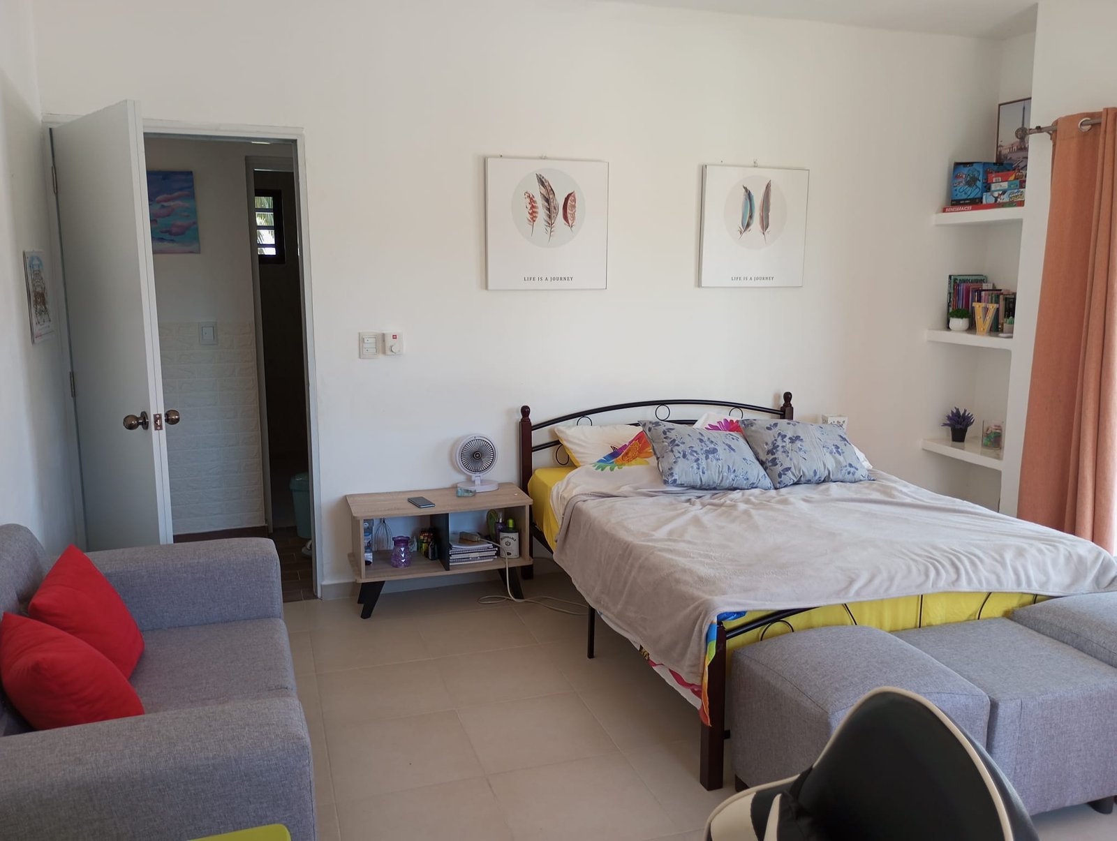 Apartamento en limon (4) Dormitorio luminoso con cama doble y sofá gris