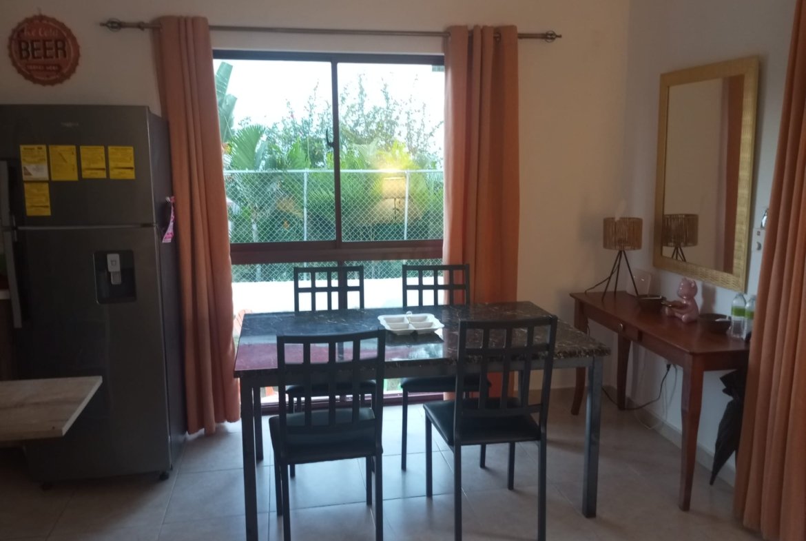 Comedor con mesa negra junto a ventana grande