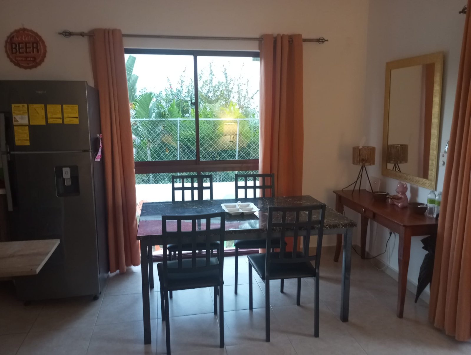 Apartamento en limon (7) Comedor con mesa negra junto a ventana grande