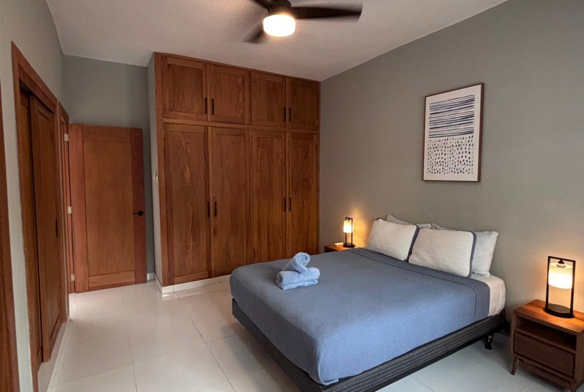 Dormitorio moderno con cama doble y armarios de madera