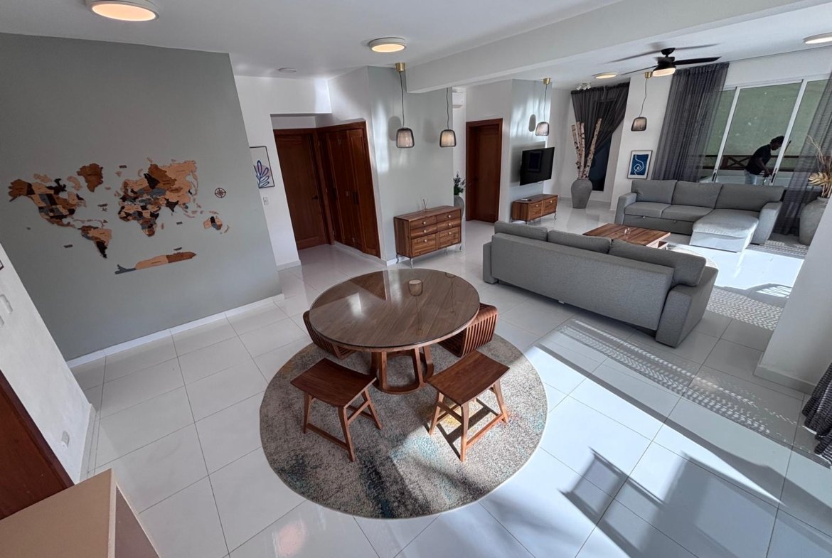 Salón moderno luminoso con sofá gris y mesa redonda