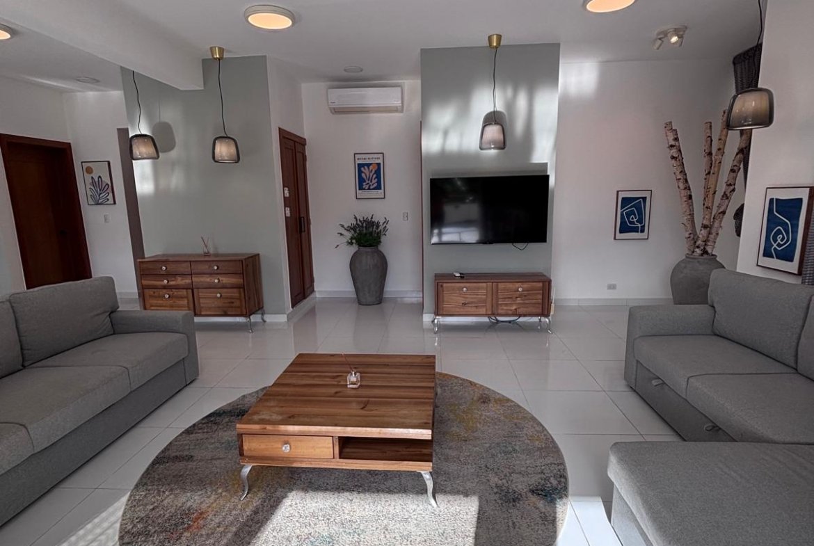 Salón moderno con sofás grises y mesa de madera
