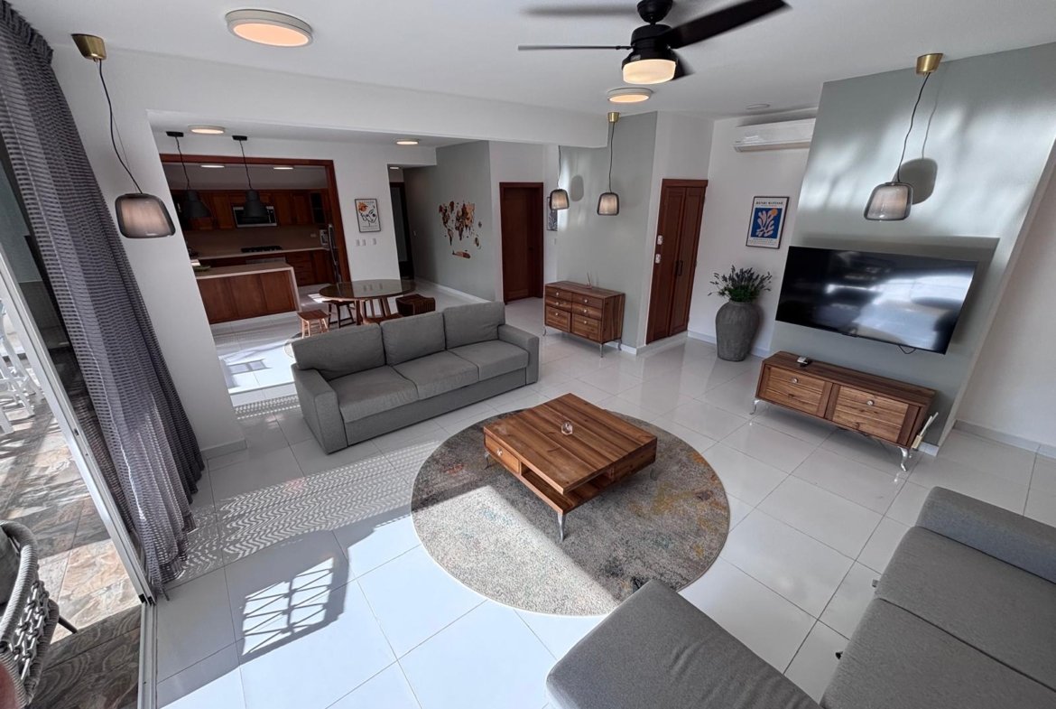 Salón moderno con cocina abierta y sofá gris