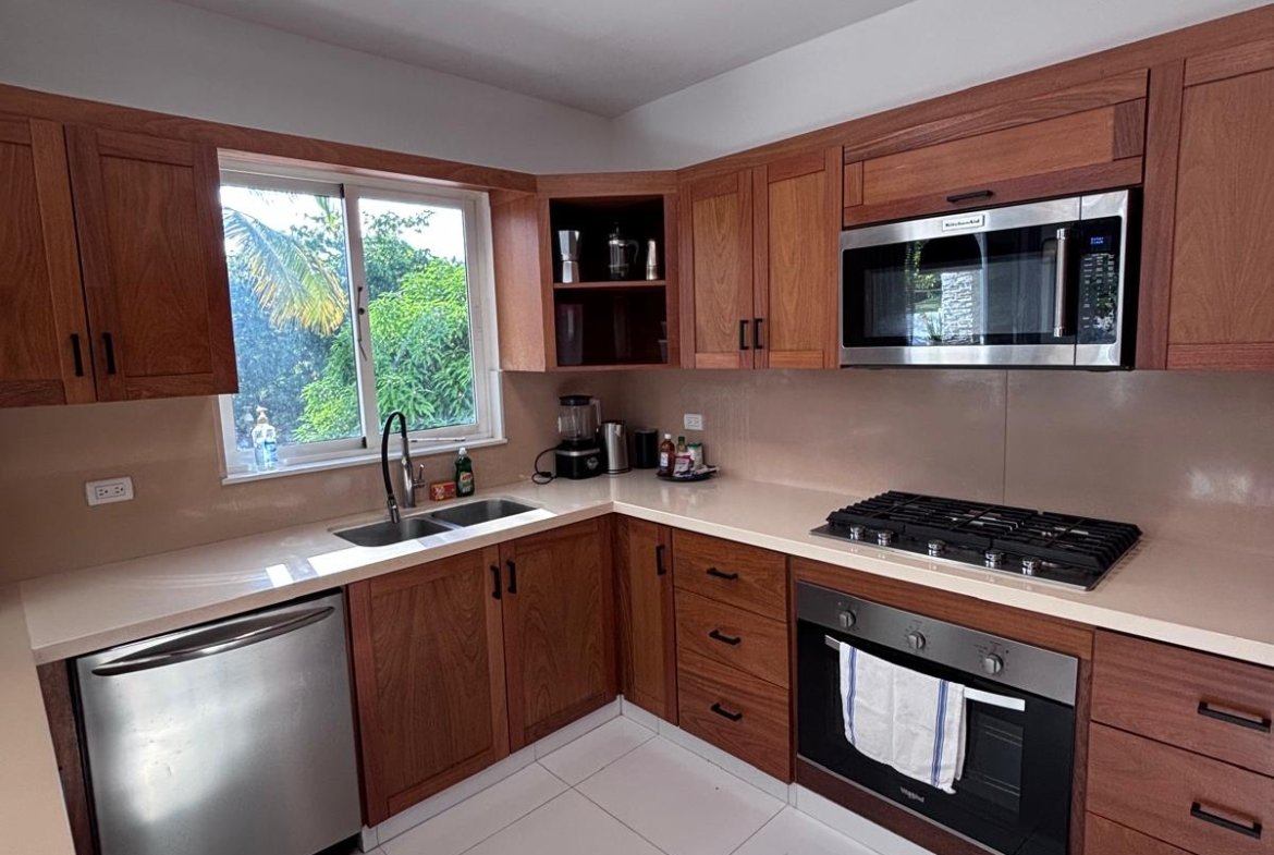 Cocina moderna con muebles de madera y electrodomésticos inoxidables
