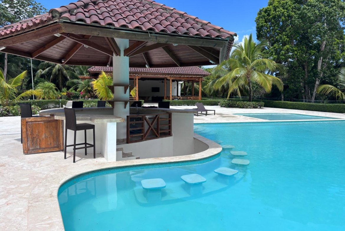 Piscina tropical con bar acuático y palmeras