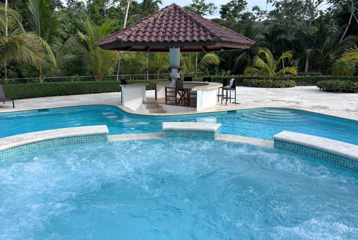 Piscina tropical con bar acuático y jacuzzi