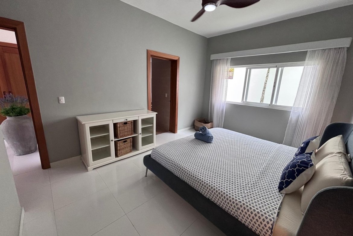 Dormitorio moderno con cama doble y ventana amplia