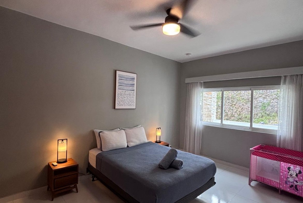 Dormitorio moderno con cama doble y cuna rosa