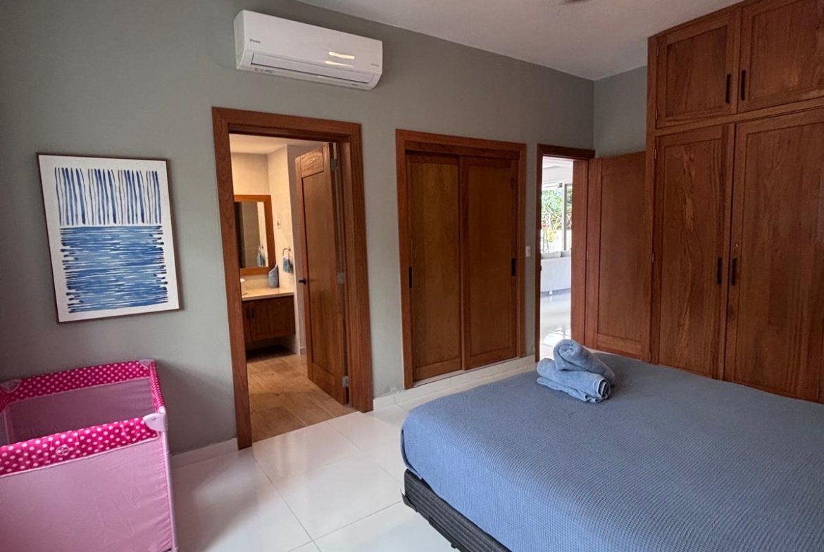 Dormitorio moderno con cama, armarios y cuna rosa
