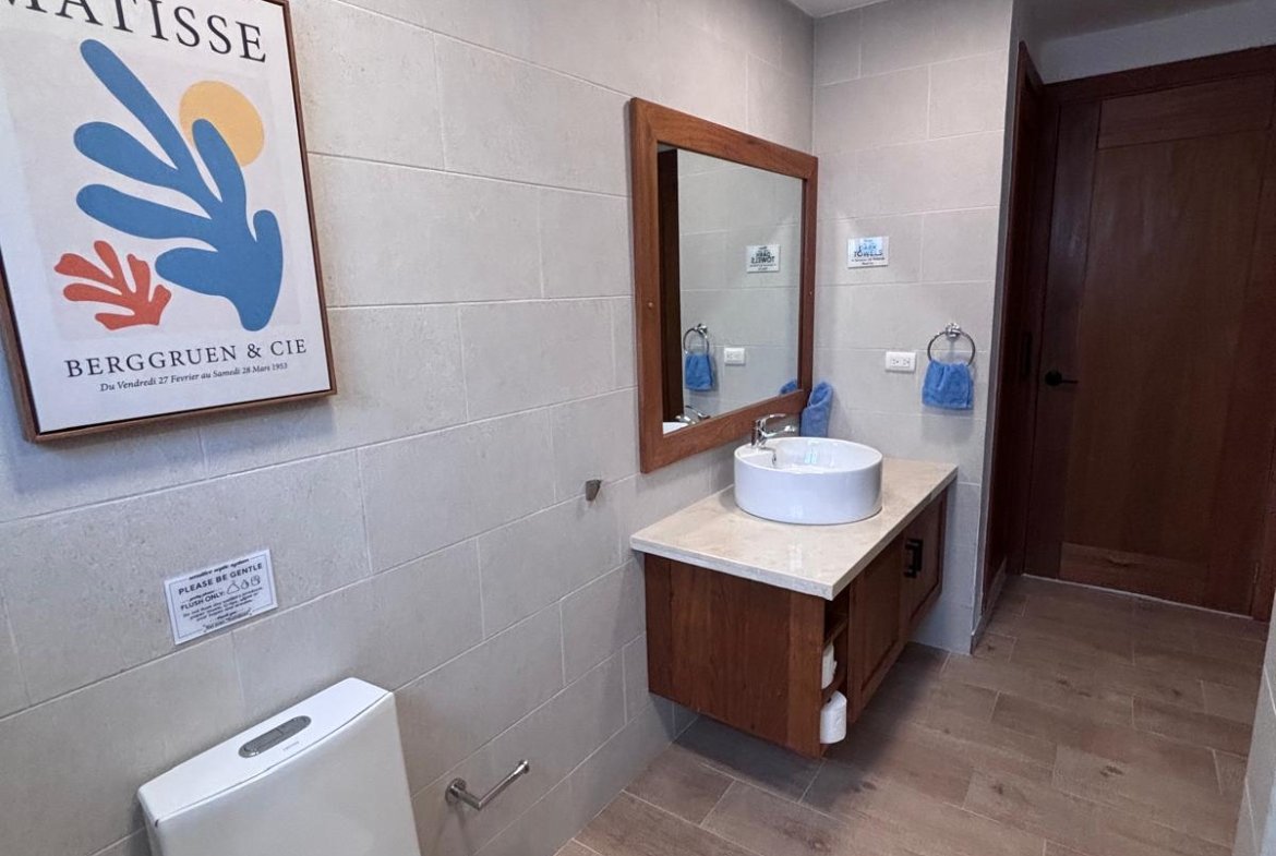 Baño moderno con lavabo sobre encimera y póster Matisse