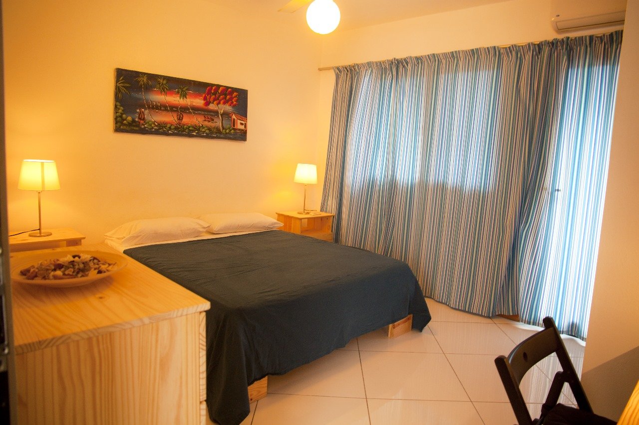 Villa El Cangrejo (12) Dormitorio acogedor con cama doble y cortinas rayadas