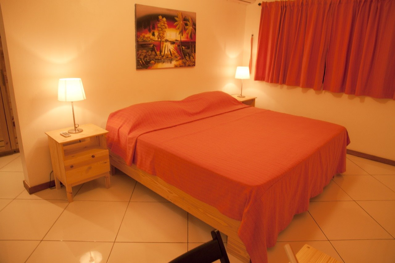 Villa El Cangrejo (14) Dormitorio con cama naranja y lámparas encendidas