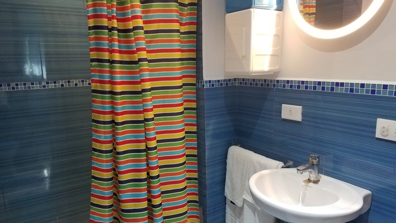 Villa El Cangrejo (19) Baño con cortina colorida y azulejos azules