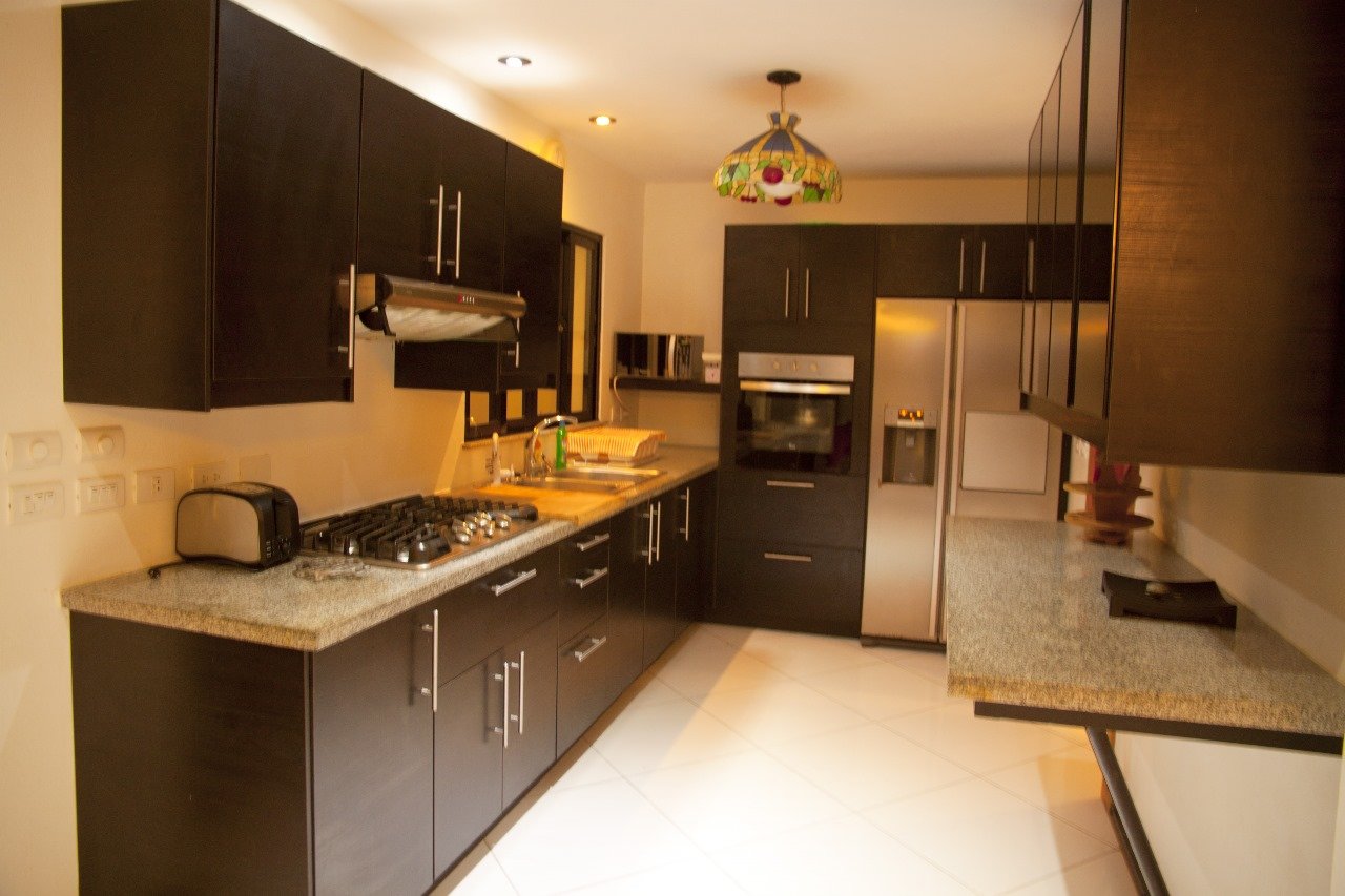 Villa El Cangrejo (2) Cocina moderna con muebles oscuros y encimera de granito