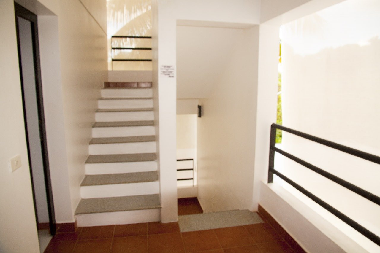 Villa El Cangrejo (4) Escalera interior moderna con paredes blancas y barandilla negra