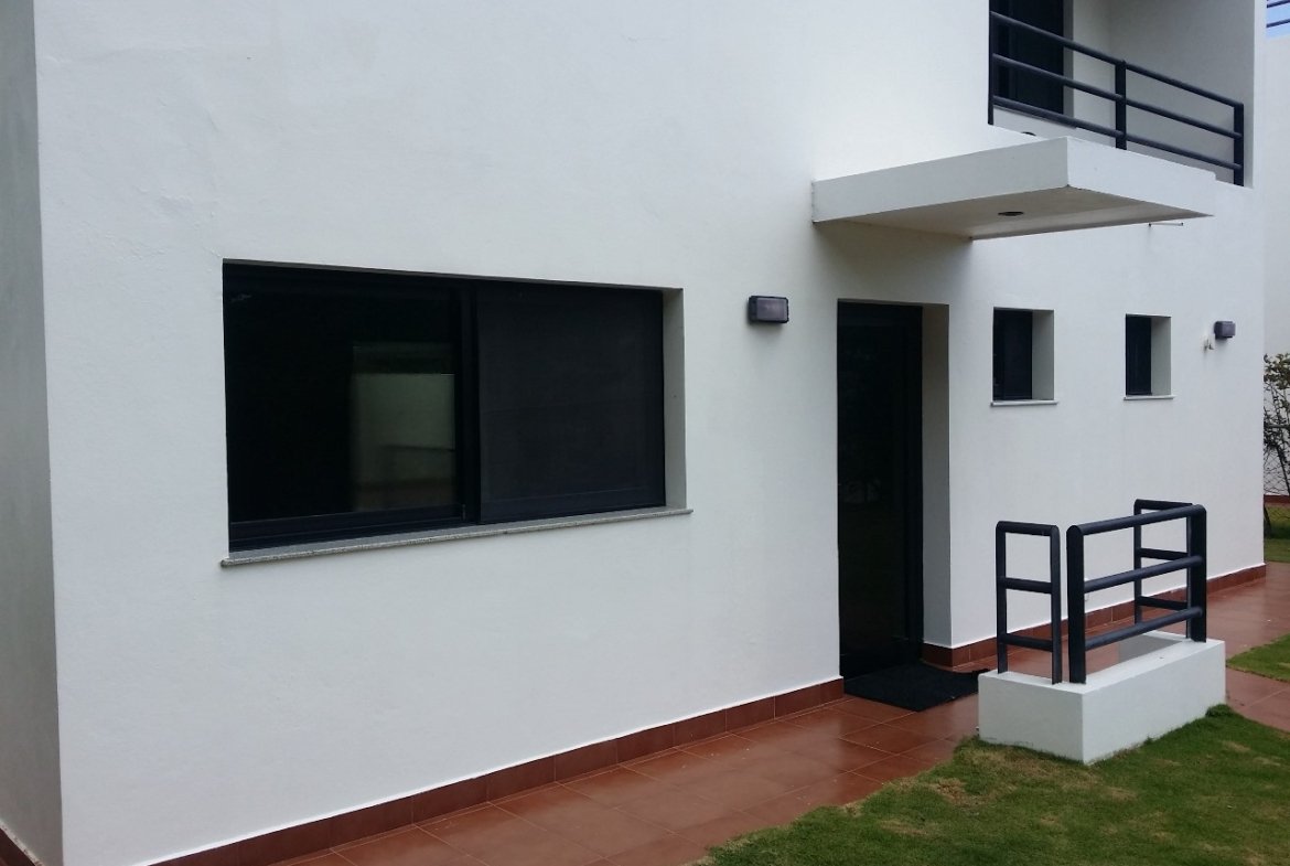 Fachada de casa moderna blanca con jardín