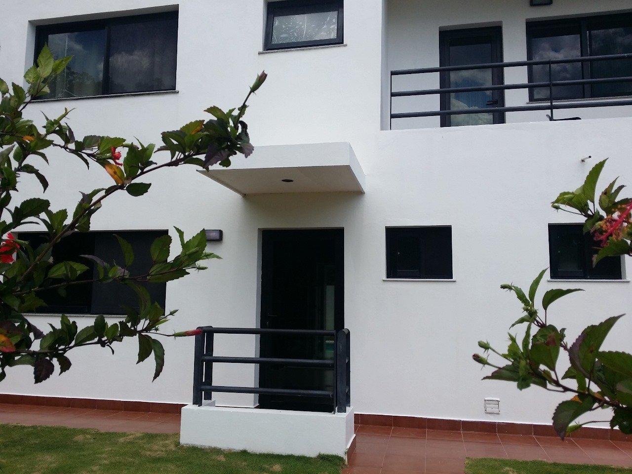Villa El Cangrejo (9) Fachada de casa moderna blanca con balcón