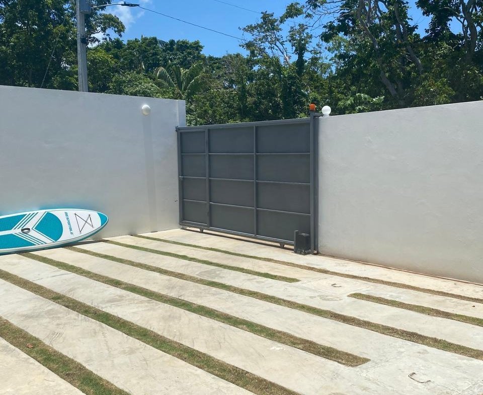 Patio moderno con puerta metálica y tabla paddle surf
