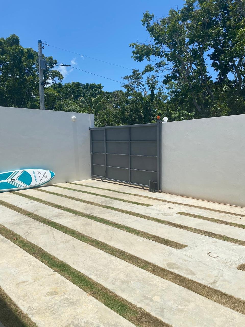 Patio moderno con puerta metálica y tabla paddle surf
