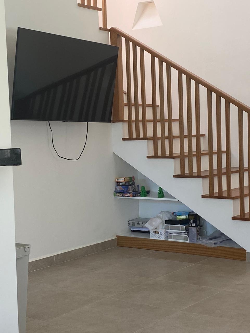 Televisor y escalera de madera en salón moderno
