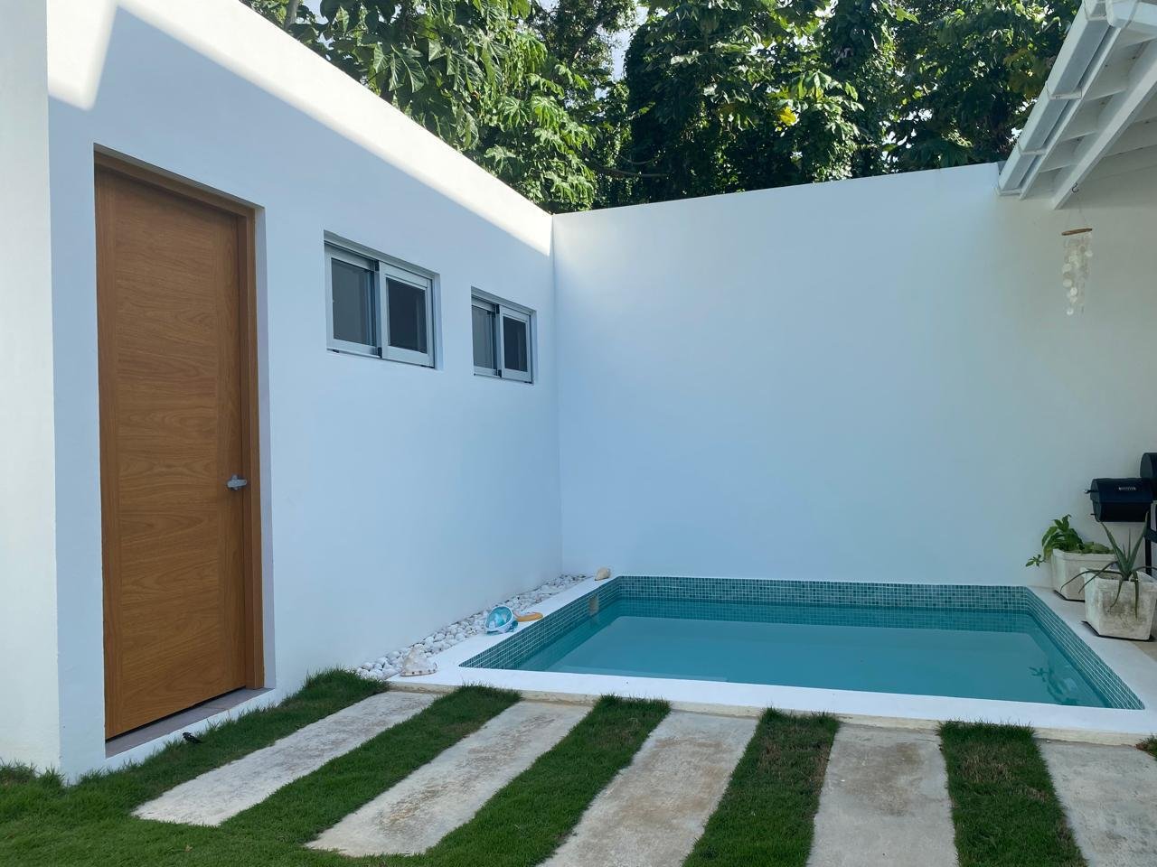 Pequeña piscina moderna en patio blanco