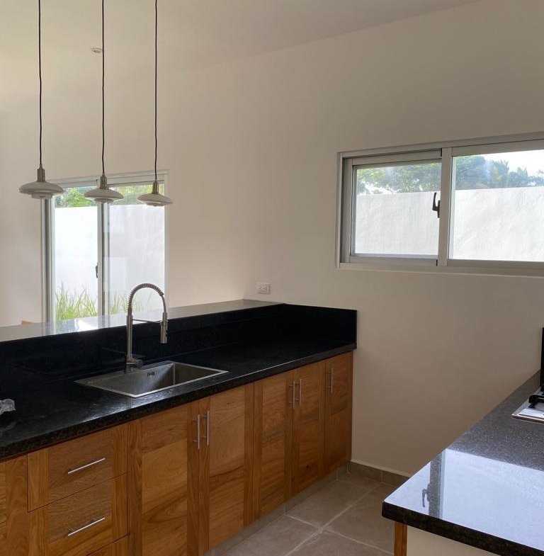 Cocina moderna con muebles de madera y encimera negra