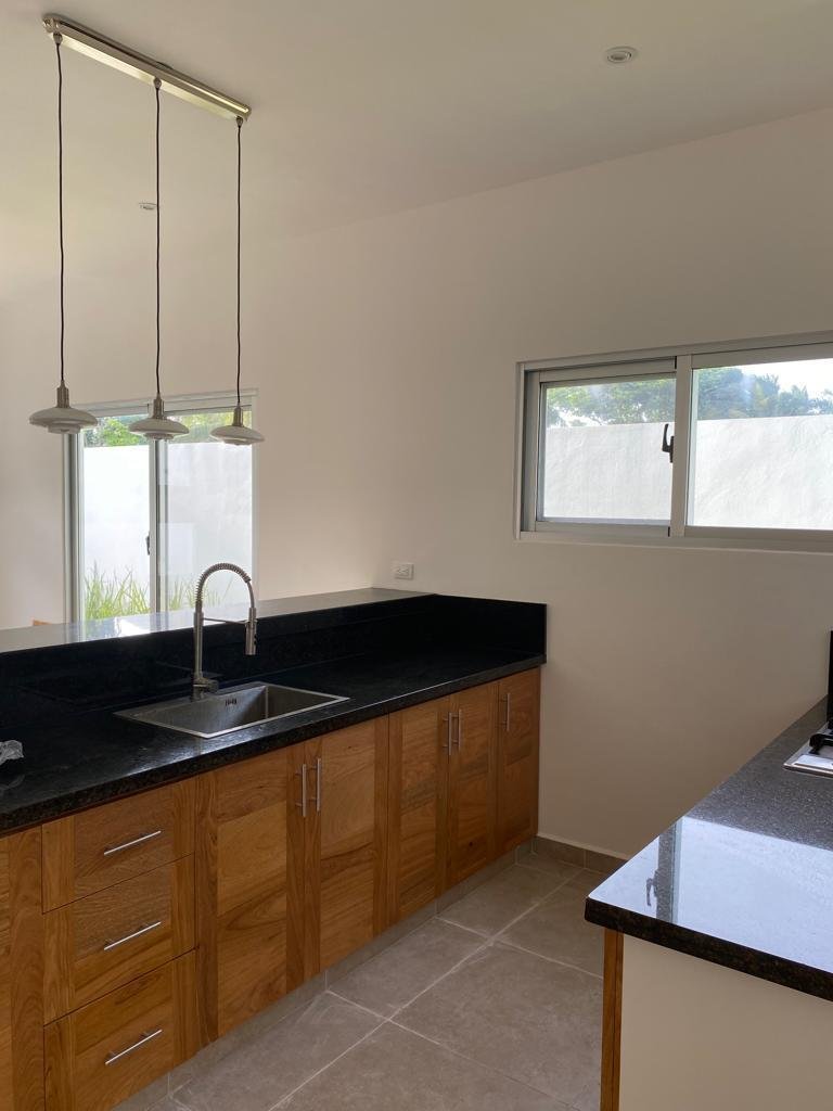 Cocina moderna con muebles de madera y encimera negra